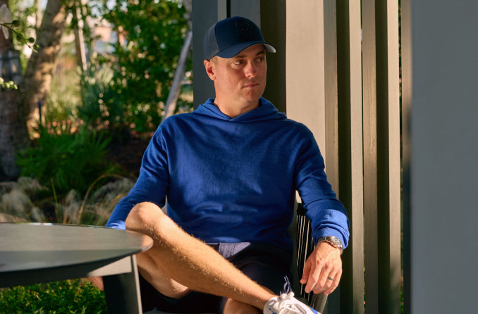 man sitting in a chair in a hooded sweater