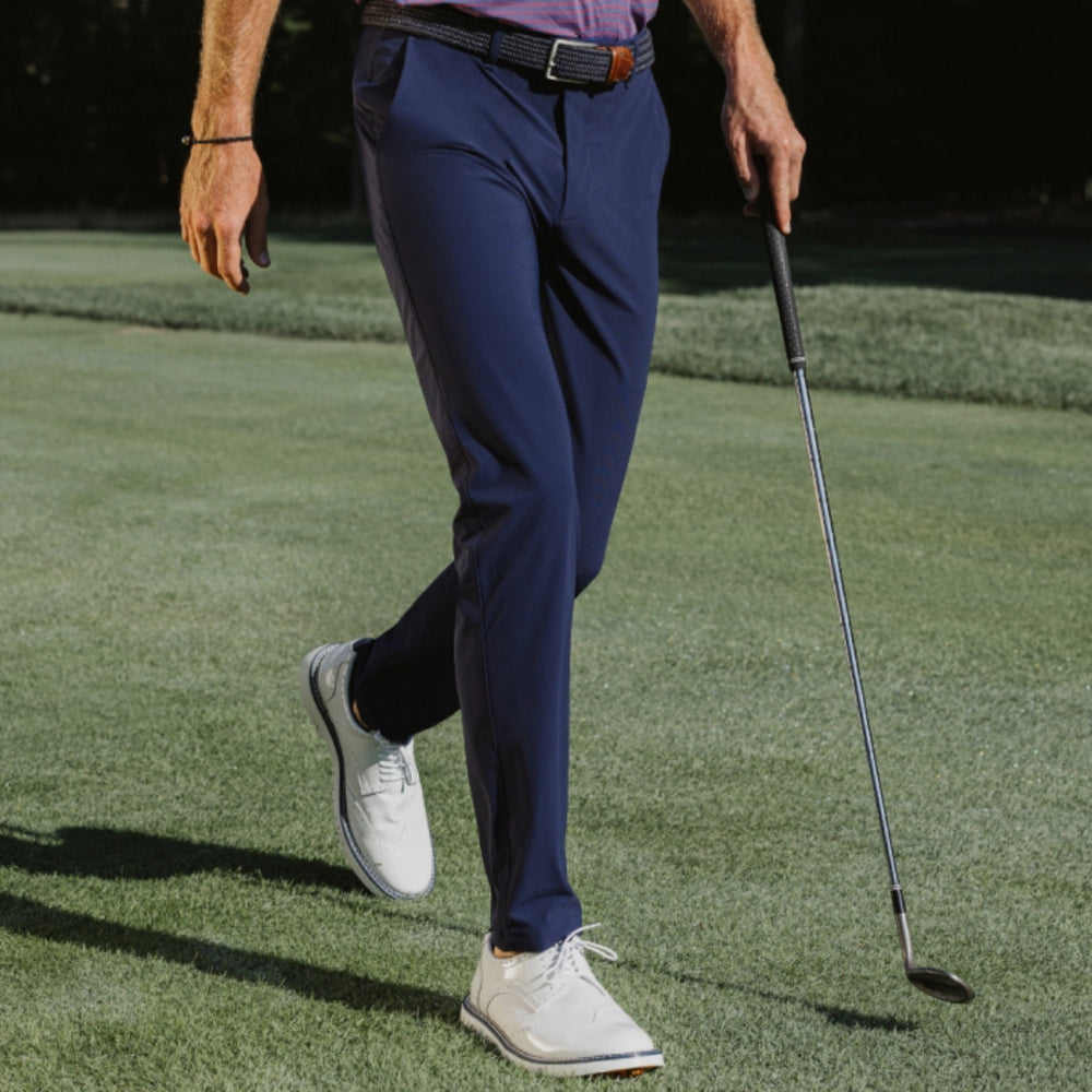 man on golf course wearing navy blue trousers