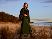 Woman standing on a beach with a scenic background